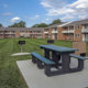 Grilling station and picnic tables outside of Levittown apartments at Orangewood Park